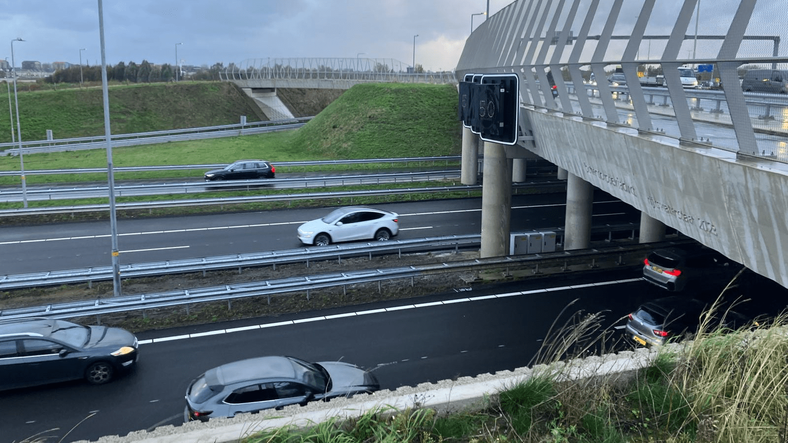De verlengde A16 bij Rotterdam is vanaf nu in beide richtingen geopend. Na de eerdere openstelling van het deel richting Dordrecht en Breda, is ook het verkeer naar Delft en Den Haag toegelaten op het nieuwe traject. Daarmee is de hele verbinding tussen de A13 bij Rotterdam The Hague Airport en het knooppunt Terbregseplein officieel in gebruik. Een nieuw hoofdstuk voor de regio Rotterdam De aanleg van deze nieuwe snelweg is bedoeld om de druk op de bestaande wegen rond Rotterdam te verlichten. Vooral de A13 bij Overschie en de A20 tussen Kleinpolderplein en Terbregseplein stonden bekend om hun dagelijkse files. Door de verlengde A16 ontstaat een extra route ten noorden van de stad, waardoor verkeer sneller en gelijkmatiger kan doorstromen. Met de ingebruikname van dit nieuwe stuk weg verbetert de bereikbaarheid van Rotterdam, maar ook van omliggende steden als Delft, Den Haag, Capelle aan den IJssel en Lansingerland. Voor automobilisten betekent dit kortere reistijden en minder sluipverkeer door woonwijken. Belangrijkste kenmerken van het nieuwe traject De nieuwe A16 is ongeveer elf kilometer lang en vormt de ontbrekende schakel tussen de A13 en de A16. De snelweg begint bij Rotterdam The Hague Airport en loopt via een grotendeels nieuw tracé naar het Terbregseplein, waar hij aansluit op de bestaande A16 richting Dordrecht. Een van de opvallendste onderdelen is de tunnel onder het recreatiegebied Lage Bergse Bos. Die tunnel zorgt ervoor dat de snelweg het natuurgebied nauwelijks verstoort – geluid en zichtbaarheid zijn tot een minimum beperkt. Verder zijn er nieuwe viaducten gebouwd, onder meer over de N471 en spoorlijnen, en zijn er geluidswallen geplaatst om de omgeving te beschermen tegen verkeerslawaai. Voordelen voor weggebruikers en omwonenden De volledige openstelling van de verlengde A16 biedt tal van voordelen: Betere doorstroming: het verkeer rond Rotterdam verdeelt zich nu over meer routes. Minder files: vooral op de A13 en A20 wordt een daling in filedruk verwacht. Betere leefomgeving: minder sluipverkeer door woonwijken en minder geluidsoverlast in drukke stadsdelen. Snellere verbinding: automobilisten uit Den Haag, Delft en het noorden van Rotterdam bereiken sneller de A16 en A20 richting het zuiden. Aandachtspunten bij de ingebruikname Bij de opening van een nieuw snelwegtraject ontstaan vaak tijdelijke aanpassingen in de verkeersstromen. Weggebruikers moeten alert zijn op gewijzigde rijroutes en nieuwe verkeersborden. Ook navigatiesystemen kunnen in de eerste dagen nog de oude situatie tonen. Daarnaast zal Rijkswaterstaat de komende tijd het verkeer en de geluidssituatie blijven monitoren om te zien of de maatregelen rondom leefbaarheid en veiligheid voldoende effect hebben. Een belangrijke stap voor de toekomst Met het volledig openstellen van de verlengde A16 is een groot infrastructureel project in de regio Rotterdam afgerond. De nieuwe verbinding zorgt niet alleen voor een vlottere doorstroming van het verkeer, maar draagt ook bij aan een beter evenwicht tussen mobiliteit, leefbaarheid en natuur. Het is een mijlpaal die de komende jaren voelbaar zal zijn voor forenzen, transporteurs en bewoners in de wijde omgeving.